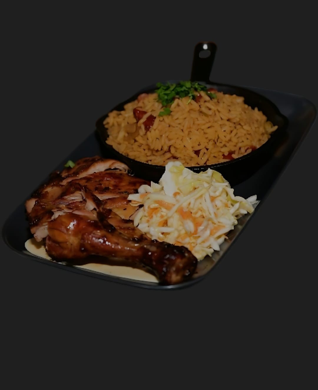 Grilled chicken with a skillet of seasoned rice and fresh coleslaw
